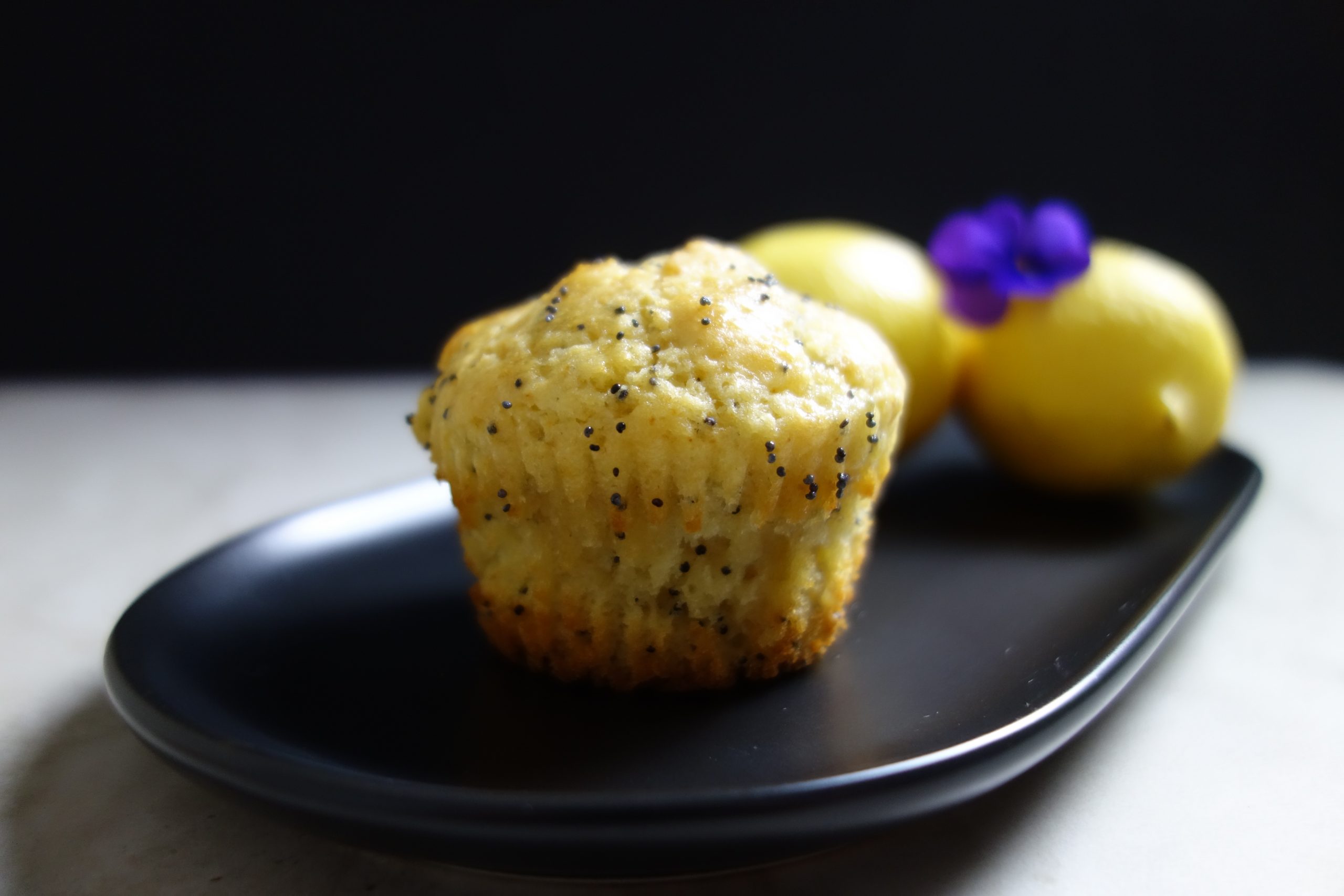 lemon poppy seed muffin on a black plate